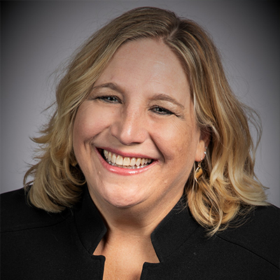 A woman with short blond hair wearing a black shirt. 