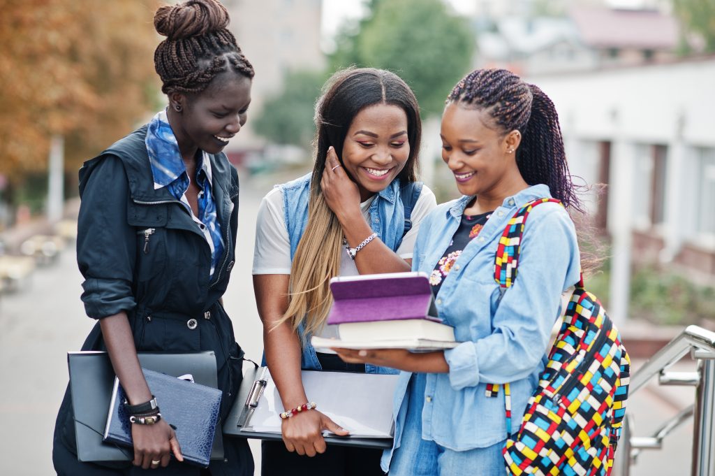 Three African Students Female Posed With Backpacks And School Items