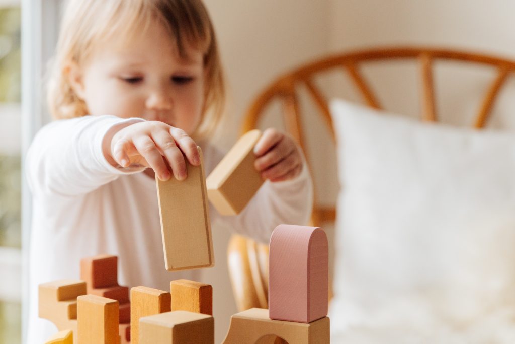 A young child plays with wooden blocks.