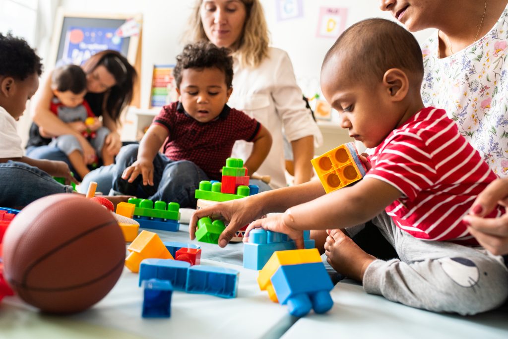 Young children play with blocks in an early childhood classroom.