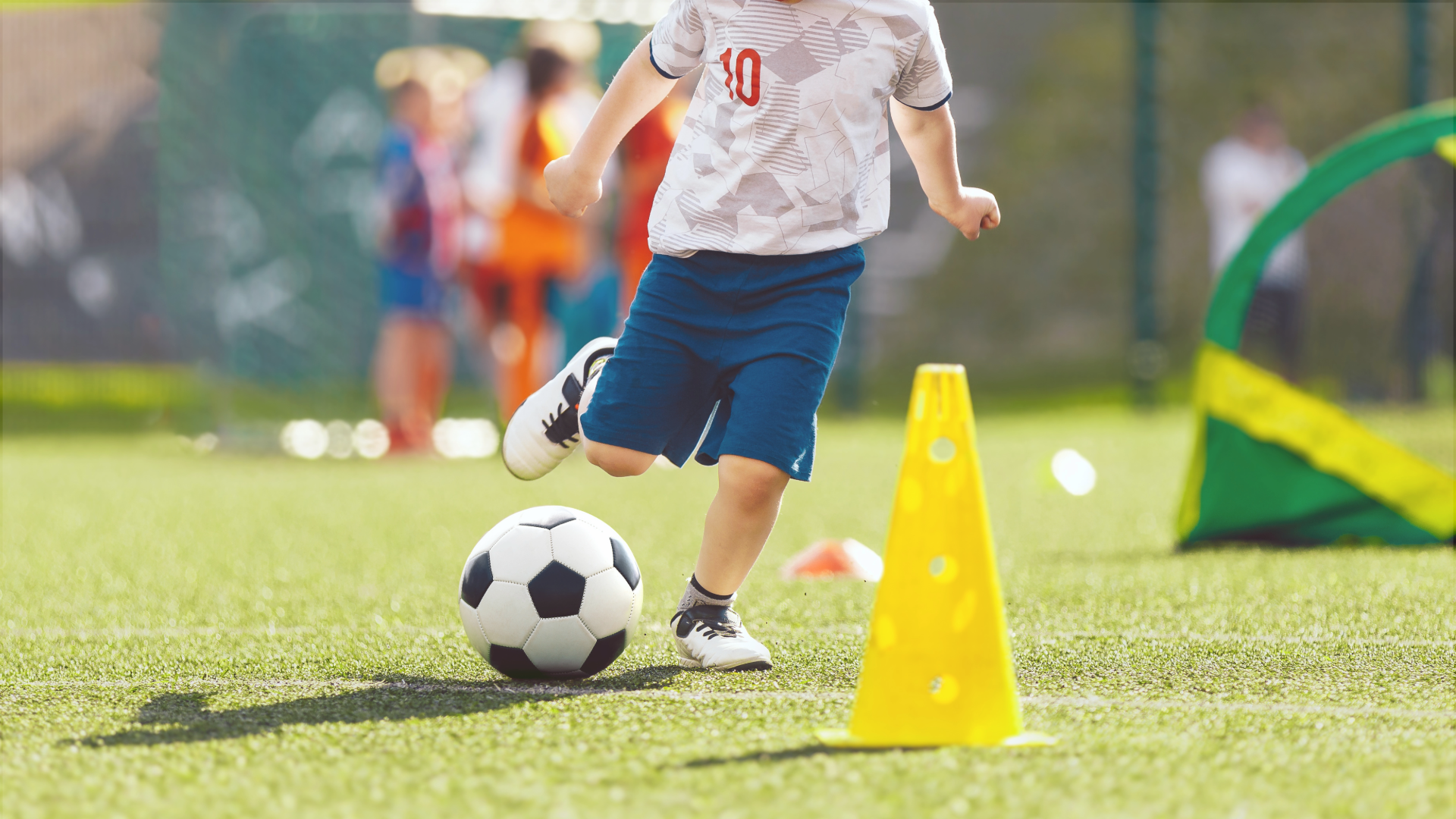 A young child plays soccer on a field.