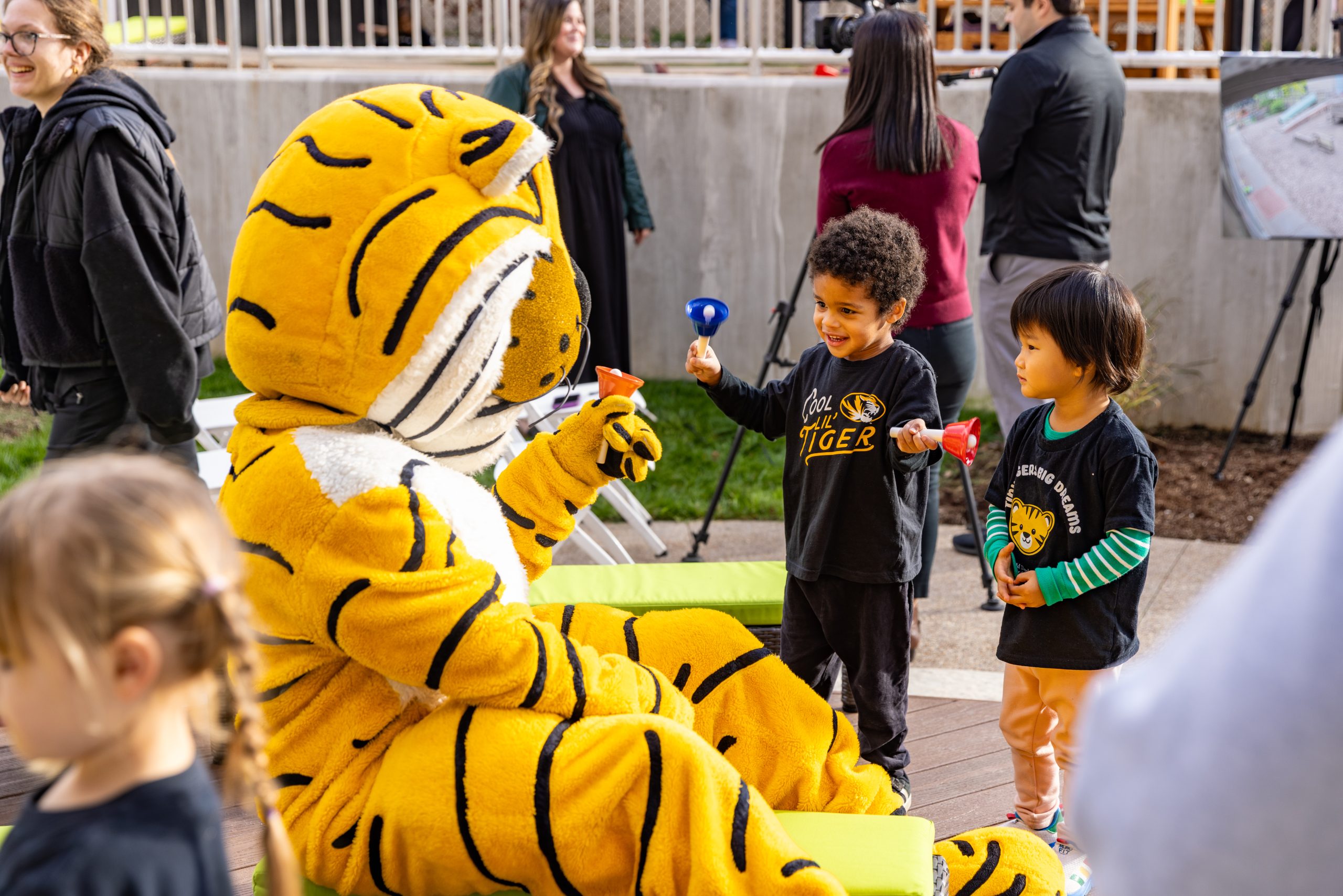 Truman playing with young children at the CDL ribbon cutting ceremony for the new playground.